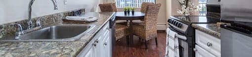Citadel in North Vancouver, BC Kitchen with patterned stone counters and a view of dining room