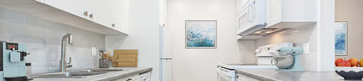 Park Towers Apartments image of kitchen showing white cabinetry and four appliances of a renovated 1 bedroom in London, ON