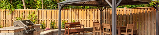 a patio with a gazebo and a grill