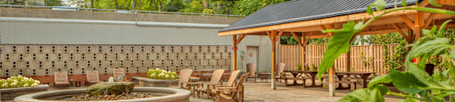 a patio with chairs and a fire pit