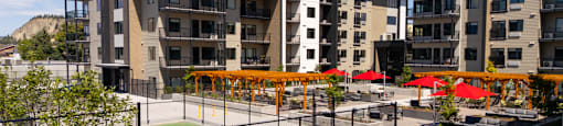 A pickleball court surrounded by chairs and umbrellas at The Ambrosi in Kelowna, BC.