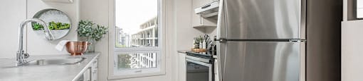 Kitchen with stainless steel appliances at Axial Towers