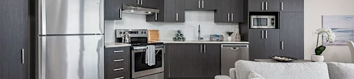 Open concept kitchen with stainless steel appliances at Axial Towers