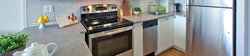 Contemporary kitchen with white cabinetry and stainless steel appliances in Whitby, ON
