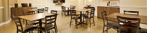 Regency Place social room with tables and chairs and tv in Whitby, ON