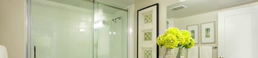 Modern white bathroom with glass doored walk-in shower at Regency Place in Whitby, ON