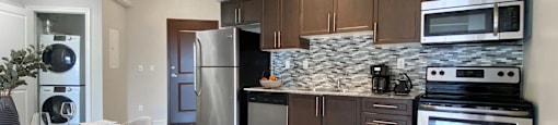a kitchen with stainless steel appliances and a table with chairs at Rittenhouse Apartments in Kitchener Ontario