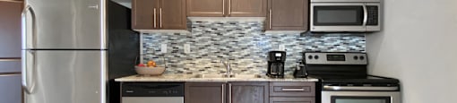 a kitchen with stainless steel appliances and wooden cabinets at Rittenhouse Apartments in Kitchener Ontario