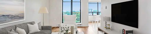 Living room, looking towards patio door and balcony, with couch, table and flat-screen tv