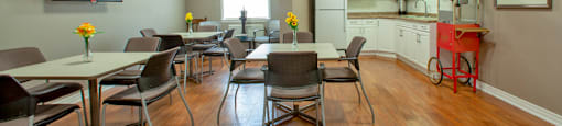 Social room with kitchenette ant tables and chairs at Riverbend Tower Apartments in Chatham, ON