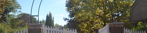 A white fence with a sign that says Riverdale on it.