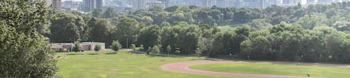 A baseball field with a city skyline in the background.