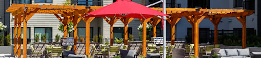A patio with a red umbrella and chairs at The Ambrosi in Kelowna, BC.