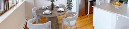 A modern kitchen with a dining table set for four  in a renovated 3 bed 2 bath suite at Somerset Place in London, ON.