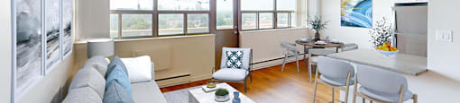 A living room with a grey couch and a coffee table  in a renovated 3 bed 2 bath suite at Somerset Place in London, ON.