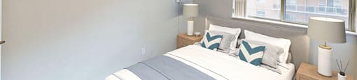 A bedroom with a large bed and a window in a renovated 2 bed 1.5 bath suite at Somerset Place in London, ON.