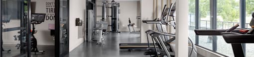 A gym with treadmills, weights, and exercise equipment.