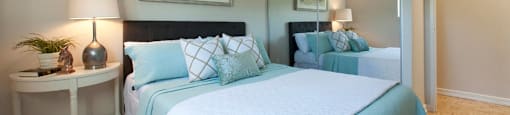 Sunnidale Place Modern bedroom with airy, light blues and whites. A mirror door closet is to the right of the bed in Barrie, ON