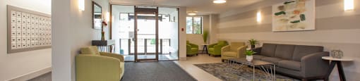 Main lobby at Sunnidale Place in Barrie, ON looking towards main door and showing couch and club chair seating and mail room