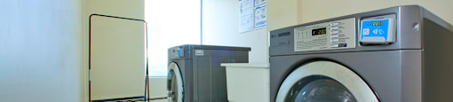 Sunset Towers laundry room with front loader washer and dryer with smart card system and laundry sink in St. Thomas, ON