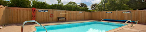 Sunset Towers outdoor pool with full-enclosed wood fence in St. Thomas, ON