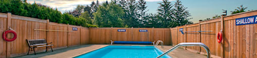 Sunset Towers outdoor pool with full-enclosed wood fence in St. Thomas, ON
