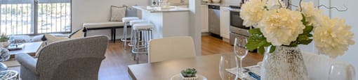 an open living room and kitchen with a table and chairs Surrey Village Apartments in Surrey BC