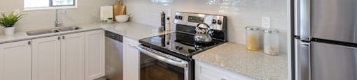kitchen with stainless steel appliances and storage at Surrey Village in Surrey BC