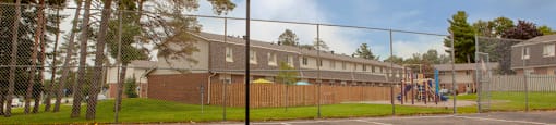 Outdoor basketball court, showing playground in the background at Tamarack Woods in Barrie, ON