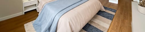 A bedroom with a bed, nightstands, and a window in Peterborough ON