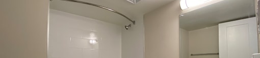 Refinished bathroom at Tarawood Place in Peterborough feature large vanity with drawers and cupboard storage and top-mount sink and tub with shower and curved shower rod