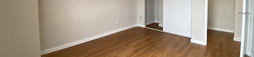 Primary bedroom in a two bedroom suite looking towards closet and bedroom door at Tarawood Place in Peterborough, ON