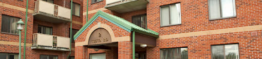 Testa Heights Apartments in Uxbridge, ON Main Entrance featuring large gardens with flowers