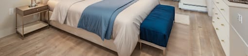 a bedroom with white walls and a bed with blue pillows