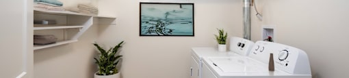 a small white laundry room with a sink and a washing machine