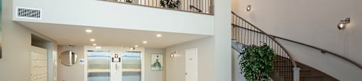 a lobby with a staircase and a lobby area with a couch and a chair