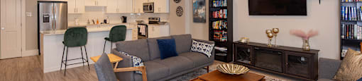 a living room with couches and chairs and a kitchen