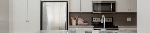 The Conservatory stunning kitchen with white cabinetry and built-in breakfast bar in Kelowna, BC
