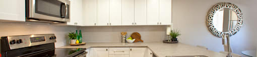 Trillium Apartments modern kitchen with white cabinetry and stainless steel appliances in Cobourg, ON