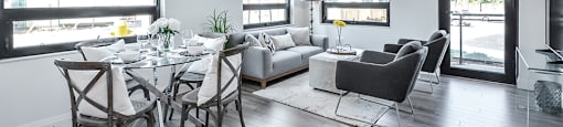 Open-concept dining and living area looking towards patio door in a 2 bed + den 2 bath variation E in building A at Trio on Belmont in Kitchener, ON