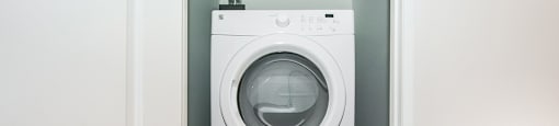 White stacked washer and dryer in-suite laundry in a 2 bed + den 2 bath variation E in building A at Trio on Belmont in Kitchener, ON