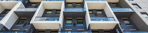 Upward view, showing balconies and windows, of one of the buildings at Trio on Belmont in Kitchener, ON