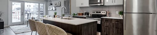 a kitchen with a large island and a stainless steel appliances at Vale Station Apartments in Waterloo ON