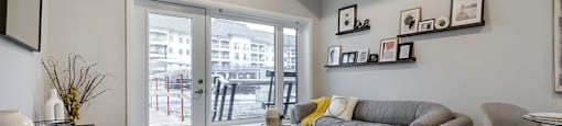 a living room with a couch and a door to a balcony at Vale Station Apartments in Waterloo ON