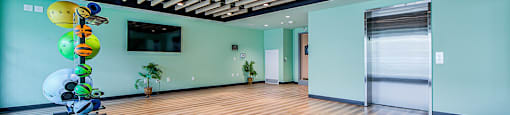 Yoga and Pilates studio with a wood-slat ceiling and elevator connected to a gym located on the floor below at Vale Station Apartments in Waterloo, Ontario