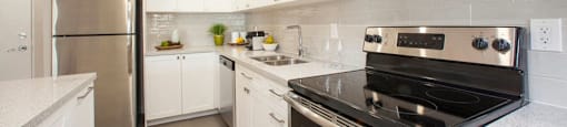 Valleyview Finished kitchen with bright pot lights and white, spotless counters. A fridge, microwave, and stove are visible in Newmarket, ON