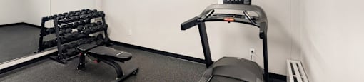 Fitness room with treadmill and weights Village Tower Toronto ON
