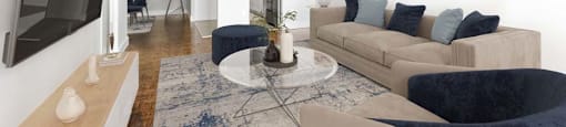 A living room with a blue rug and a grey sofa.