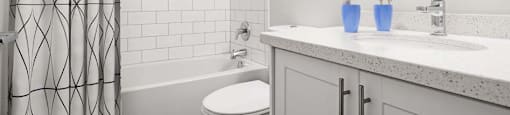 A white bathroom with a toilet, sink, and shower.