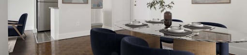 A dining room with a table set for two and a blue chair.